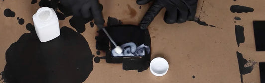 Dauber de lana aplicando sellador acrílico en el trozo de cuero negro